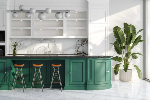 Modern luxury kitchen with emerald green cabinetry and stylish bar stools that line the marble island.